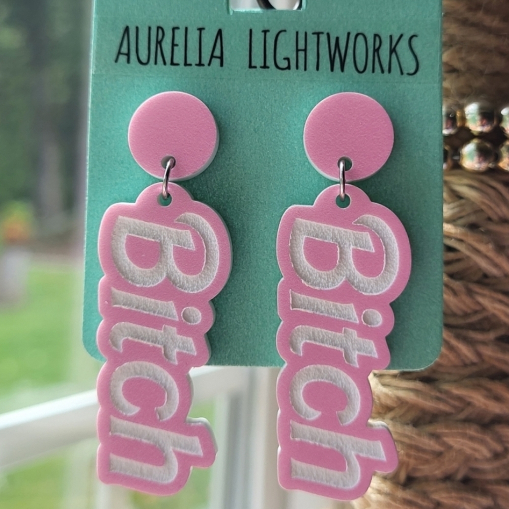 Laser engraved Barbie-themed "B!tch" earrings